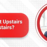 A family sits on a couch wrapped in warm clothes and blankets. Text reads, "Why Is It So Hot Upstairs But Cold Downstairs?" with the Sanders & Johnson logo—discover how a ductless mini split could solve your home's comfort issues.